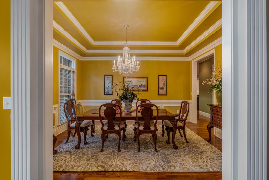 Formal dining room with chair rail and chandelier